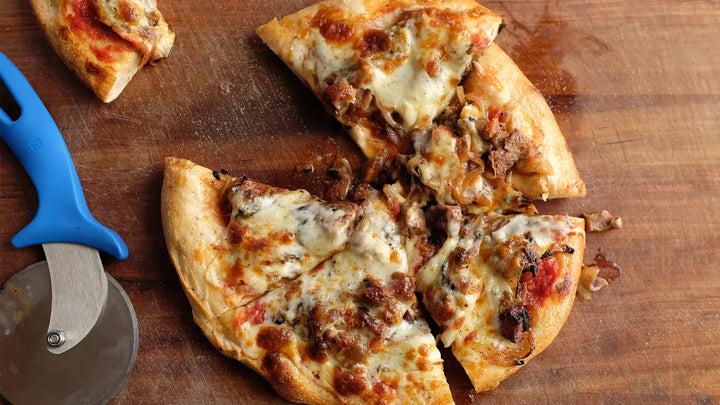 Woord fired homemade pizza with onions, cheese and wagyu strip steak