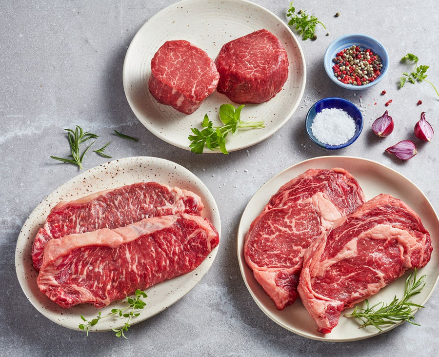 Two plated Filet Mignon, Striploin and Ribeye raw steaks